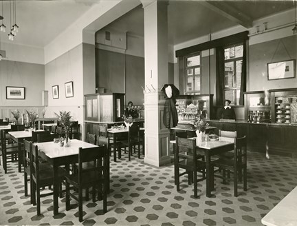 Svartvit interiörbild av restaurang Ejdern där två personer ur personalen står vid disken.