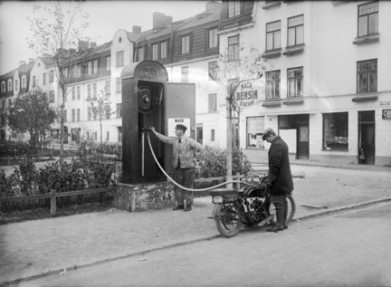 Vattenledningsvägen i Midsommarkransen. Mack bensinpump vid Julikullen. I bakgrunden Aprilgatan i kvarteret Silverpoppeln.