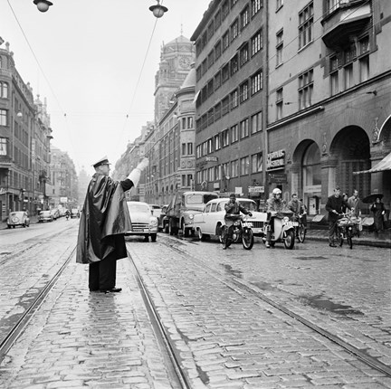 Trafikpolis med cape och vita handskar.