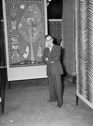 Stig Lindberg stående vid mönstrade tygvepor.