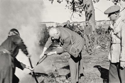 En man som släcker en brand. Stor rökutvckling i bilden pga branden. 