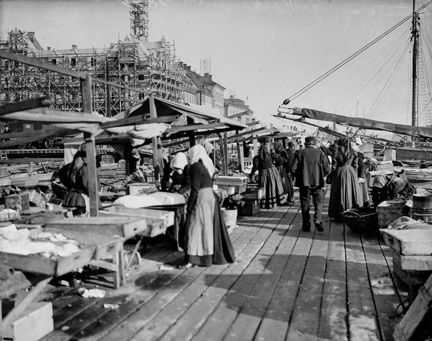 Människor rör sig vid försäljningsstånd.